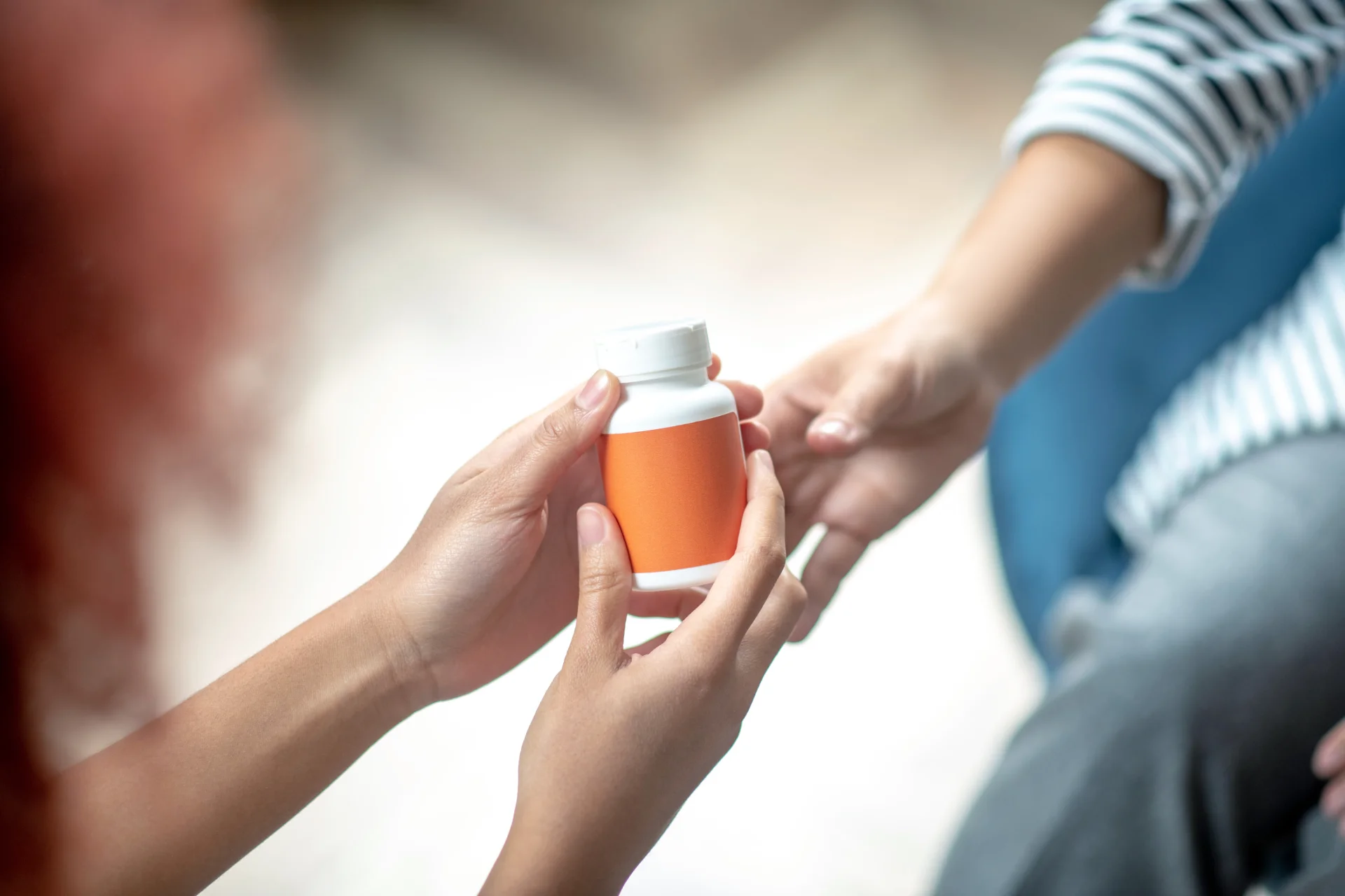 Person giving pills to another person